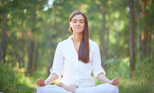 concentrated woman meditating in nature